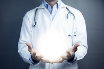 Young doctor against dark background