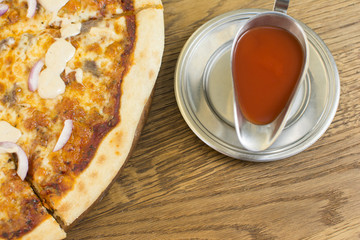 Hot pizza with melting cheese on a rustic wooden table. Delicious meal in the restaurant.