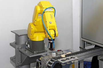 Yellow robot arm at production line