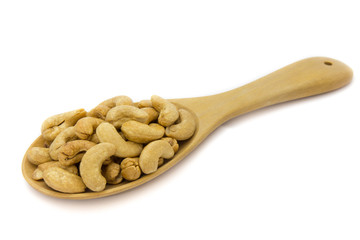 Cashew nuts in wooden spoon isolated on white background. Concept food image