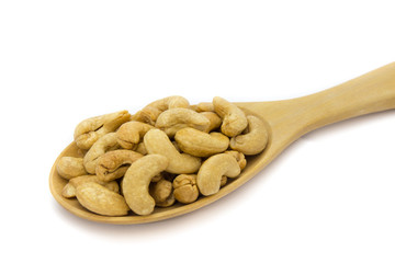 Closeup of cashew nuts in wooden spoon isolated on white background. Concept food image
