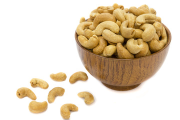 Cashew nuts in wooden bowl and wall isolated on white background. Concept food image