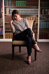 Young caucasian woman dressed like Jackie Kennedy poses in a library