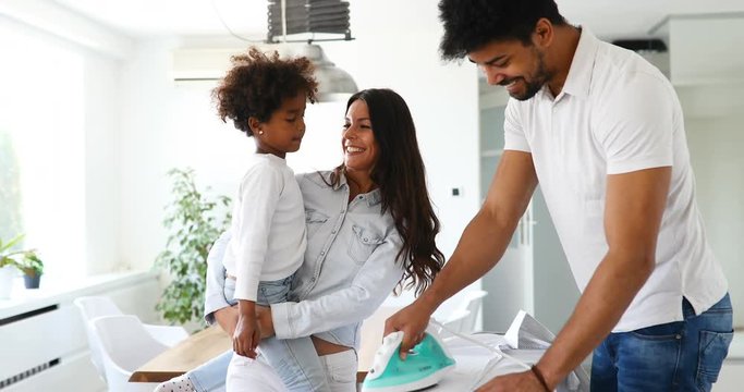 Young couple at home doing hosehold chores and ironing