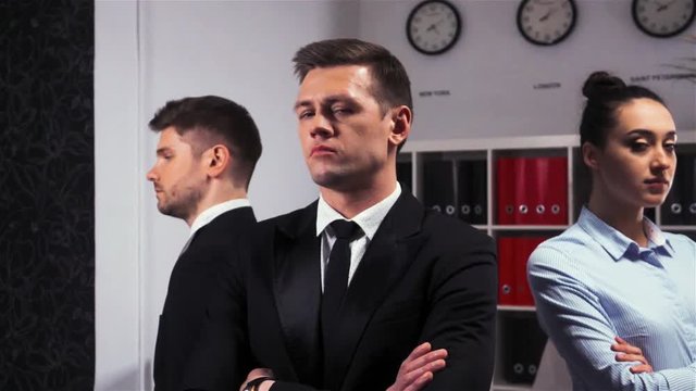 Cool Epic shot of three 3 confident attractive handsome business managers businessman and businesswoman office inside turn their head to camera. super slow motion