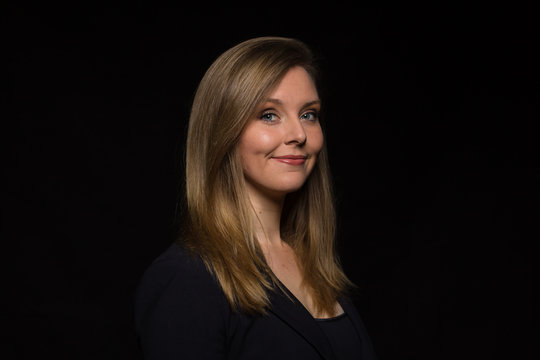 Young Caucasian Woman Headshot Against Dark Background