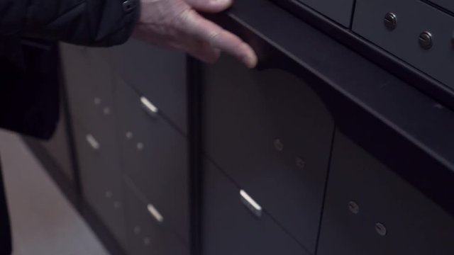 Unrecognisable bank manager hands pulls out foldable table in safe depository for businessman client to use