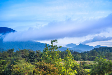 Obraz premium Clouds drifting over forests and mountains