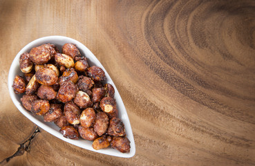 Sugared peanuts on the wooden background