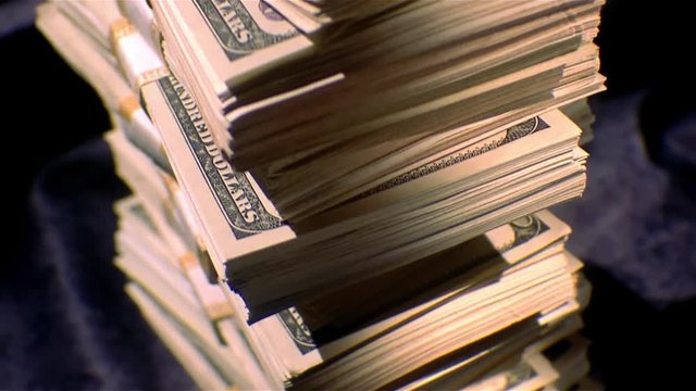 Pan up stacks of $100 dollar bills.