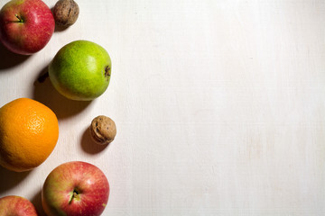Pear, apple and nutsleaves on the white wooden table