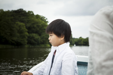 A boy looking at the pond from the top of the boat