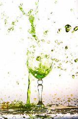green wine splash in the glass on white background,green water drop splash on white background