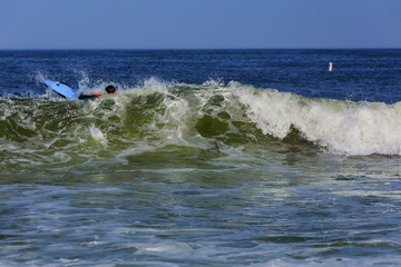 Surfer riding large ocean wave at the day time