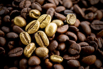 Gold coffee beans on a pile of coffee beans. The concept of luxury is extraordinary.