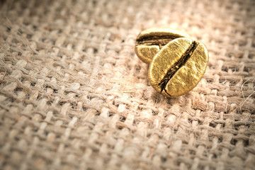 Roasted coffee beans gold on sackcloth with copy space, The concept of luxury is extraordinary