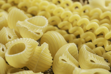 Close of uncooked macaroni . Mixed media