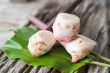 Fresh galangal on wood texture.