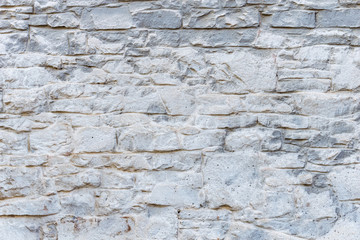 Background texture of an old stone wall hue sharkskin, smeared with white paint.