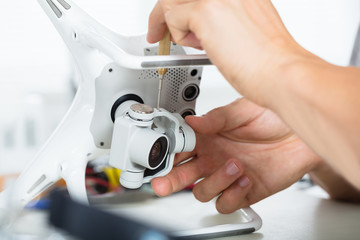 Male's Hand Repairing Action Camera On Quadrocopter Drone