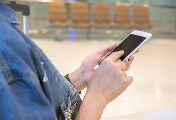Selected focus on women hand using a smart phone for searching information in the airport
