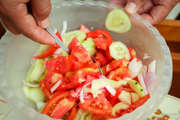 Detail of preparing mixed vegetable salad in kitchen.