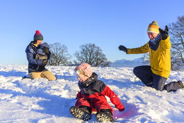 Fototapeta na wymiar junge Familie genießt den Winterurlaub im Schnee