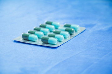 drug capsule green - azure or treatment medication in packages plastic pill. on  blue fabric table ...