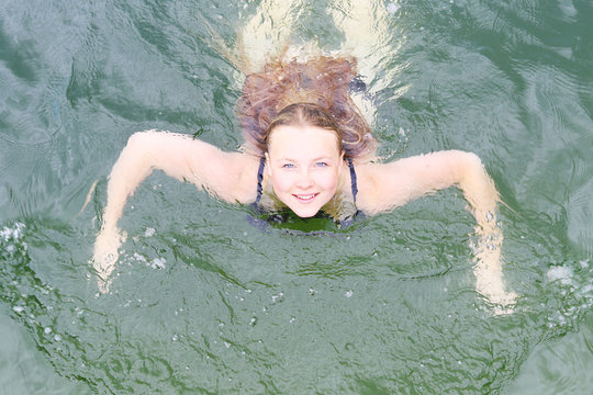 Young woman swimming in a river