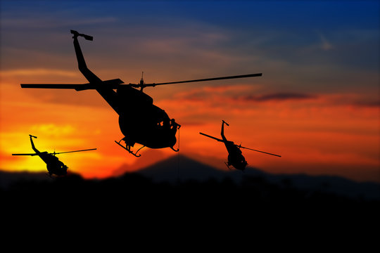 soldier silhouette in rappelling climb down from helicopter on sunset with copy space add text