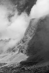 Black and white mountains with clouds. Atmospheric phenomena concept