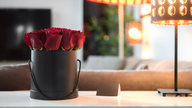 Fototapeta Roses in black box standing on the white table