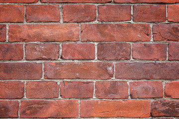Close-up of an old and aged red brick wall texture background with vignetting.