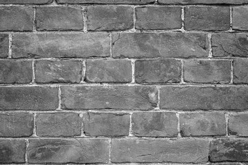 Close-up of an old and aged brick wall texture background with vignetting in black and white.