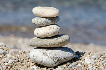 Fototapeta na wymiar pyramid of colorful pebbles . Rock Zen in the background of the sea. Concept of harmony and balance.