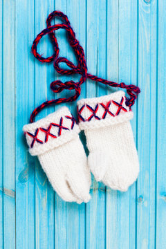 ett par stickade lovikka vantar mot turkos tr&auml; bakgrund