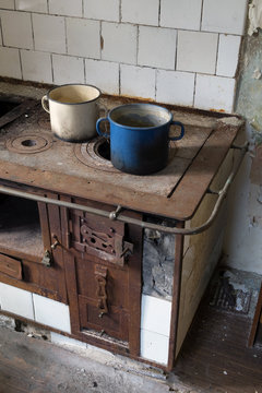 Rusty old wooden stove with metal pots on it.