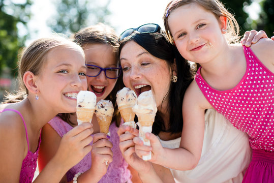 Mother And Children Sharing Ice-cream. Fun And Bonding.