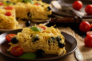 Pasta casserole with tomatoes, olives and cheese.