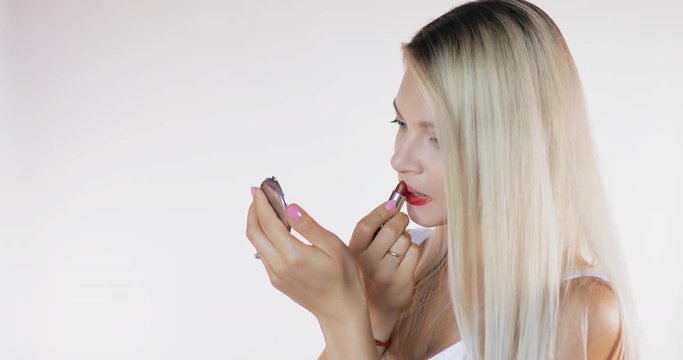 Angry woman doing bad makeup on white background with sound