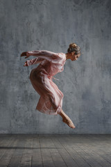 Young beautiful dancer is posing in studio