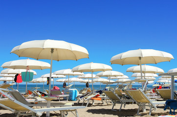 Fototapeta na wymiar Umbrellas and gazebos on Italian sandy beaches. Adriatic coast. Emilia Romagna region
