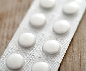 Pills on wood background with shallow dof
