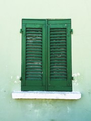 Wooden green window of a green house (Pesaro, Italy)