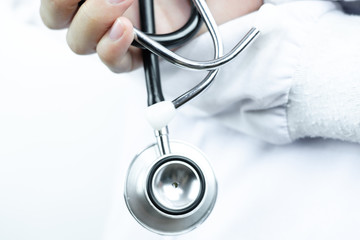 Close up view of black stethoscope that holding on hand on white isolate background
