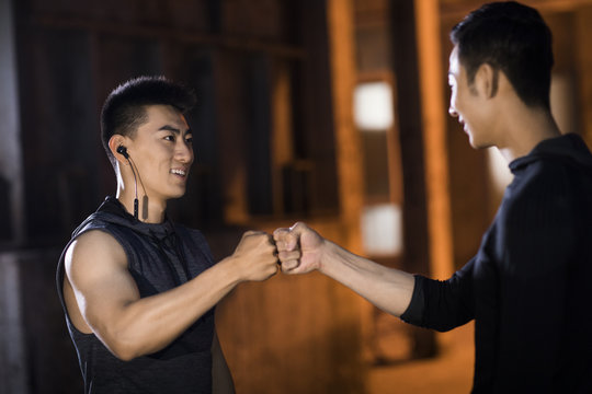 Young friends fist bumping