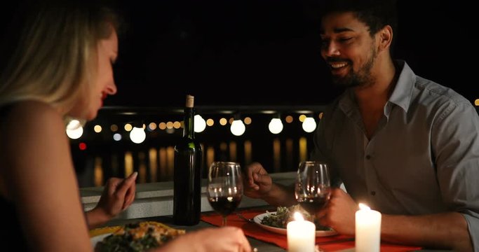 Young beautiful couple having romantic dinner on rooftop