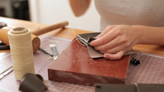 Woman making of leather wallet