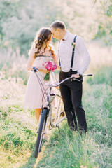 The lovely photo of the bridesmaid and best man looking at each other in the sunny forest.