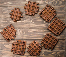 homemade fresh rye waffles in oval shape on wooden background, top view